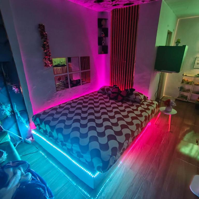 a bedroom with a bed with pink and blue lights at Jace Haven Deluxe in Binangonan
