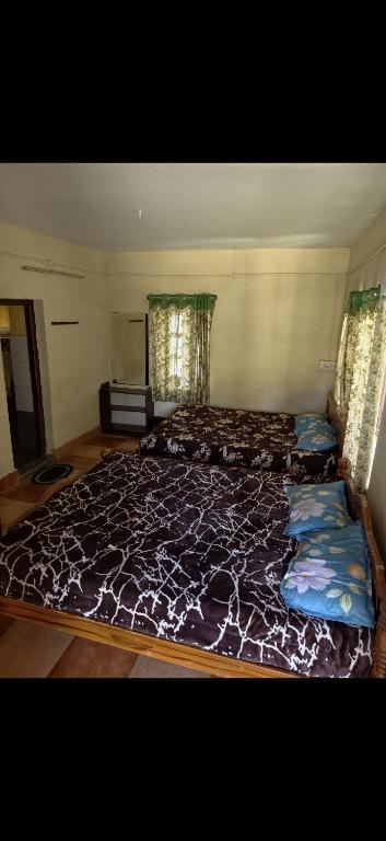 a bedroom with two beds in a room at NILORA stay KODAI in Kodaikānāl