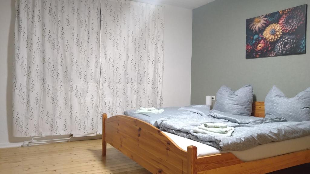 a bedroom with a bed with blue pillows and a window at Otto`s Ferienwohnung in Biedenkopf