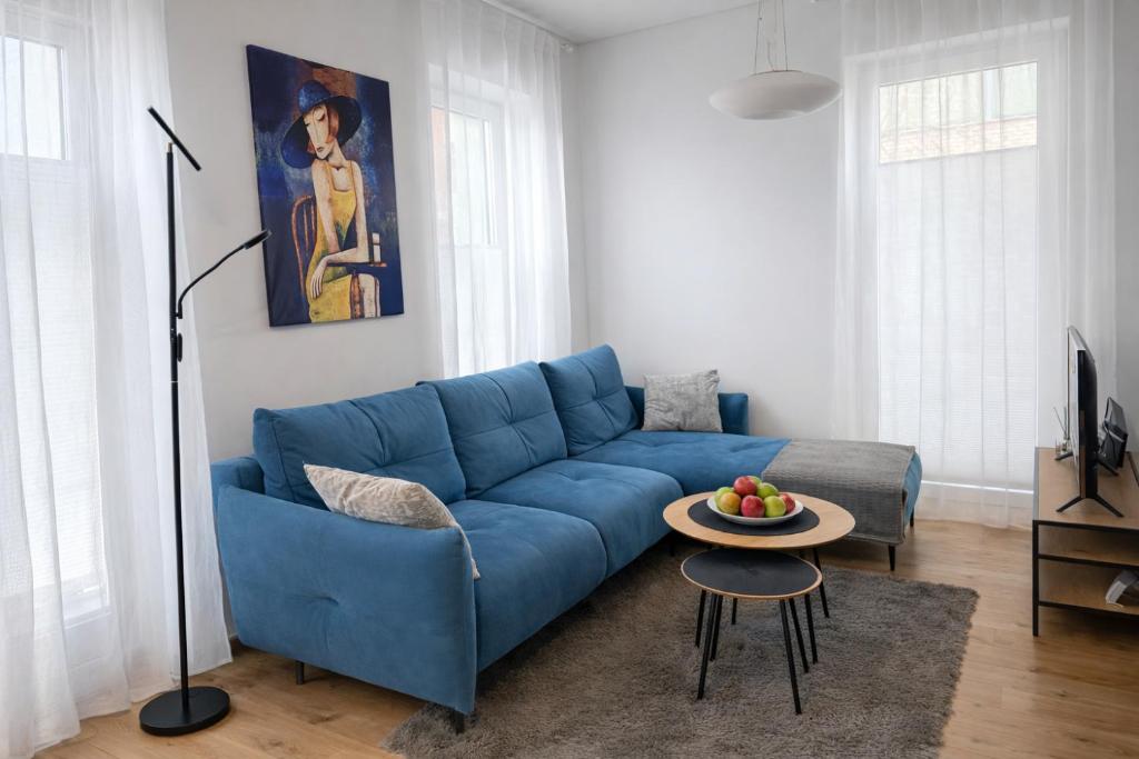 a blue couch in a living room with a table at V71A Kauno Centre in Kaunas