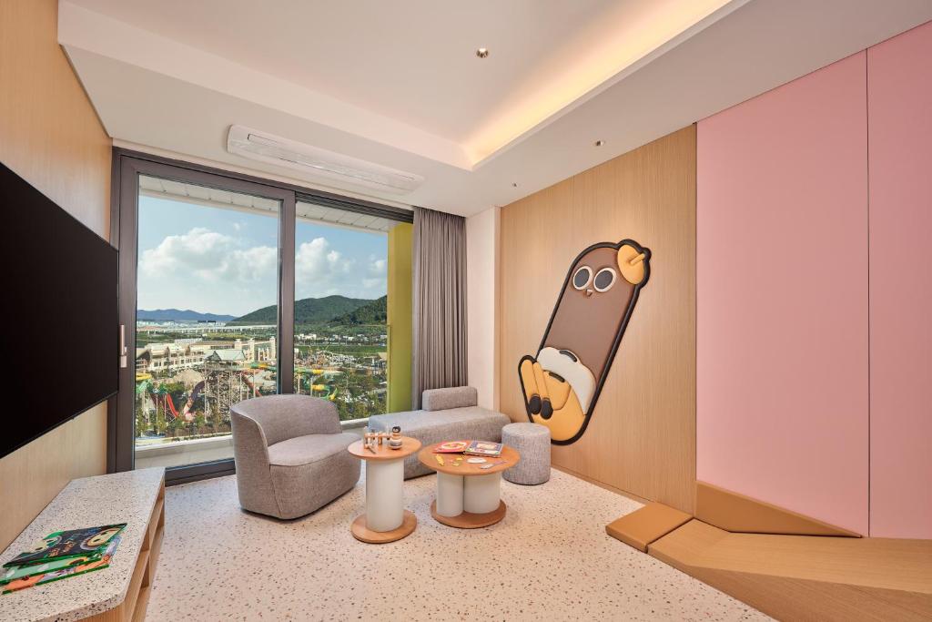 a living room with a cartoon character on the wall at Lotte Hotels & Resorts Gimhae in Gimhae