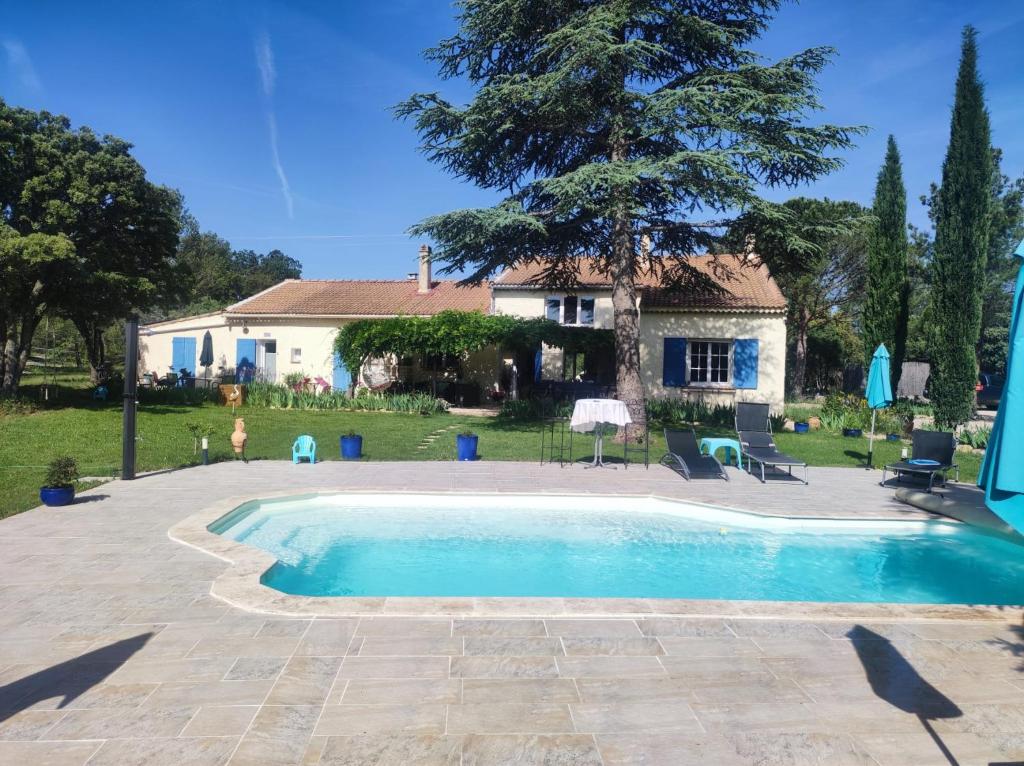 a swimming pool in front of a house at La Margottière chez isa et titi in Rians