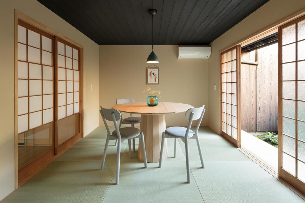 ein Esszimmer mit einem Holztisch und Stühlen in der Unterkunft Nakano-an in Kyoto