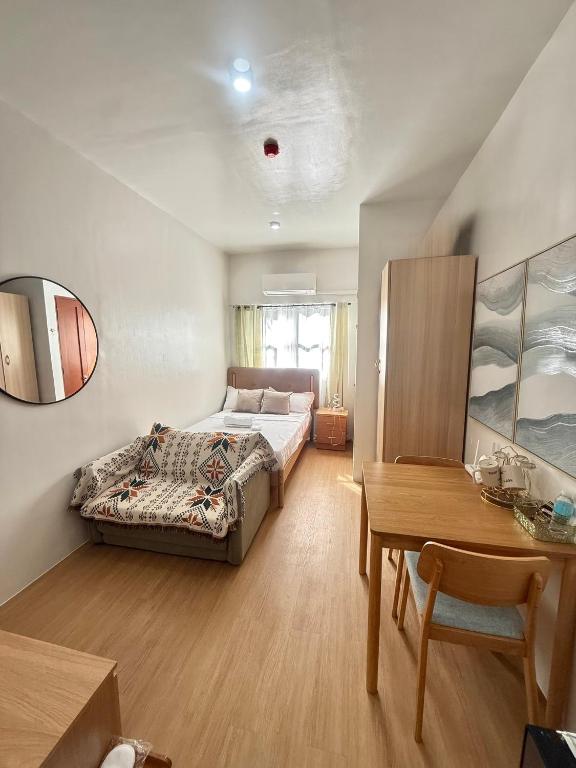 a bedroom with a bed and a desk and a table at E&J Solace Studio Mactan Bayanihan Flats 2 in Maribago