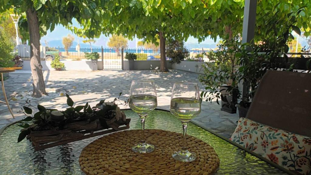 two glasses of white wine sitting on a table at ILIOVASILEMA - Ηλιοβασίλεμα in Pefki