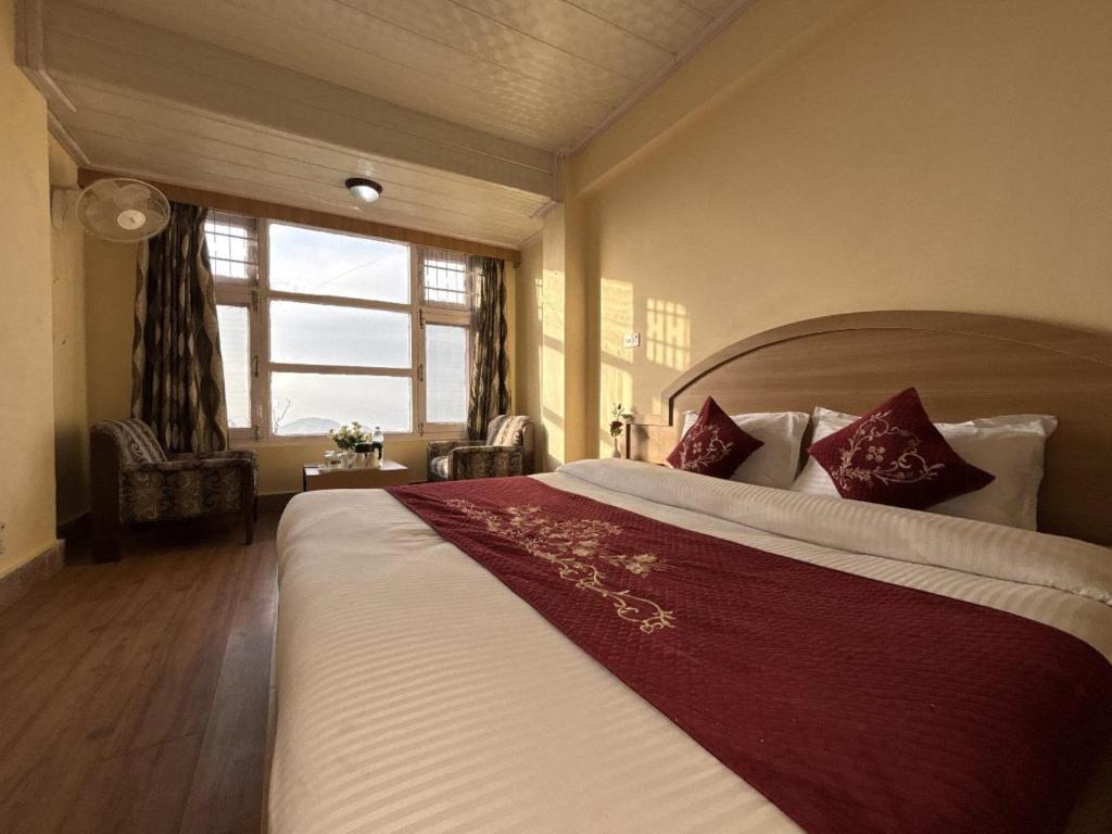 a bedroom with a large bed and a window at New Amar Palace Shimla with Mountain View in Shimla