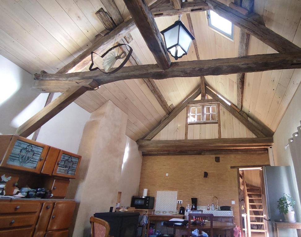 a large room with a wooden ceiling with windows at L'Escalier des Rêves - Rose in Saint-Sauveur-en-Puisaye