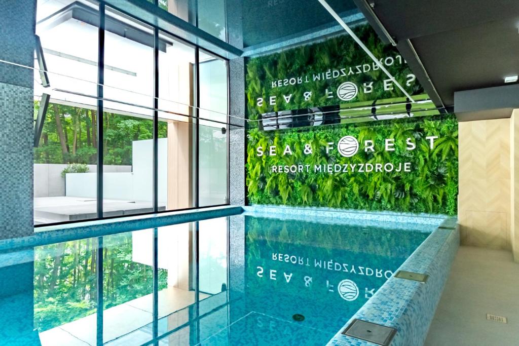 a swimming pool in front of a building at Forest Międzyzdroje in Międzyzdroje