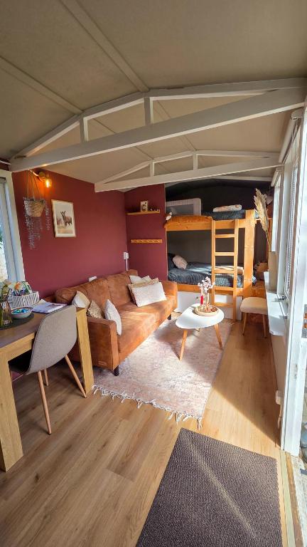a living room with a couch and a table at Tinyhouse op de Veluwe, het buitenleven in Oene