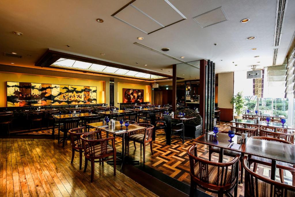 a restaurant with tables and chairs and a bar at New Otani Inn Tokyo in Tokyo