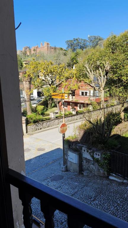 a view of a street from a balcony with a sign at La Aldea 3 , CENTRO de Comillas, Parking Público y vistas Universidad Pontificia in Comillas