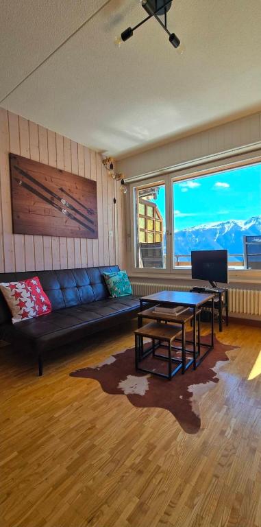 a living room with a couch and a table at Charmant petit appartement in Ovronnaz