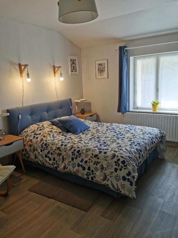 a bedroom with a bed with a blue headboard at Chez Isa et Christophe in Mogeville