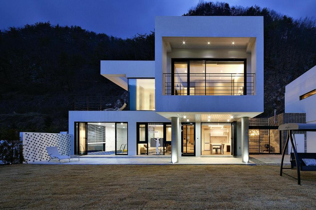 a large white house with a lot of windows at Be,Bridge Pool Villa Resort in Yeongwol