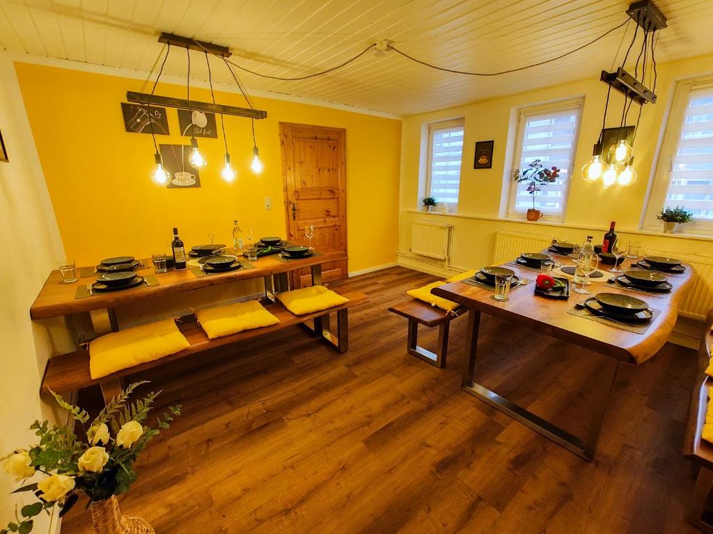 a dining room with yellow walls and a table and chairs at Altenauer Kaffeehaus in Altenau
