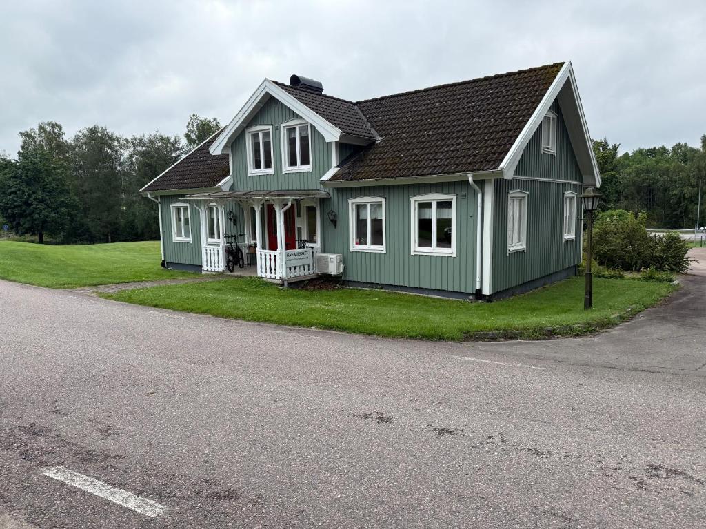 a green house on the side of a road at Hagabergets Vandrarhem in Ullared