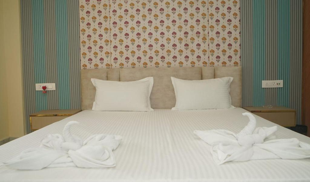 a bed with two white towels on top of it at Siddharaj Resort in Mal bazar