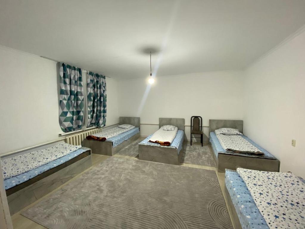 a room with three beds in a room with at Жумгал гостевой дом in Chayek