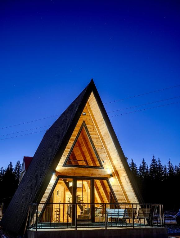 a large church with a triangular roof at night at Pine Forrest Uskoci in Žabljak