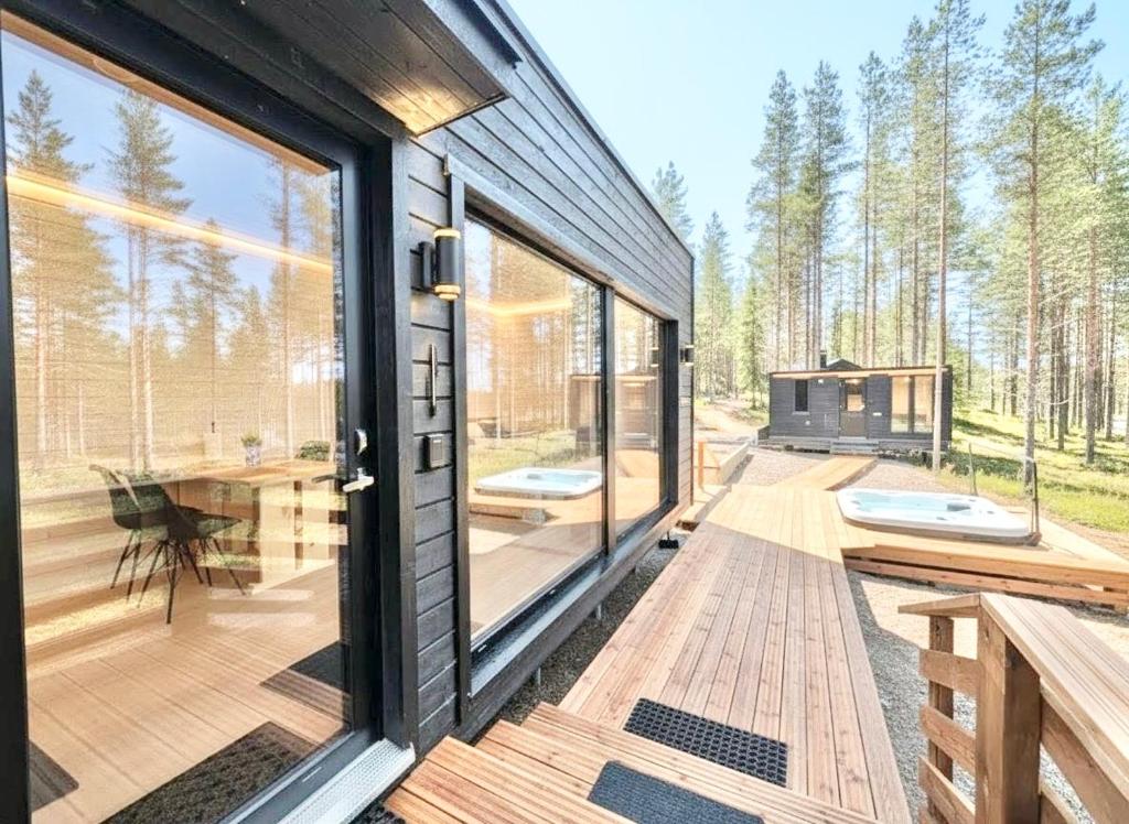 a house with a large glass door and a deck at Spa Cabin by Hossaville in Hossa