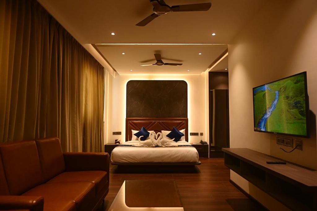 a hotel room with a bed and a couch at Golden Suites in Bangalore
