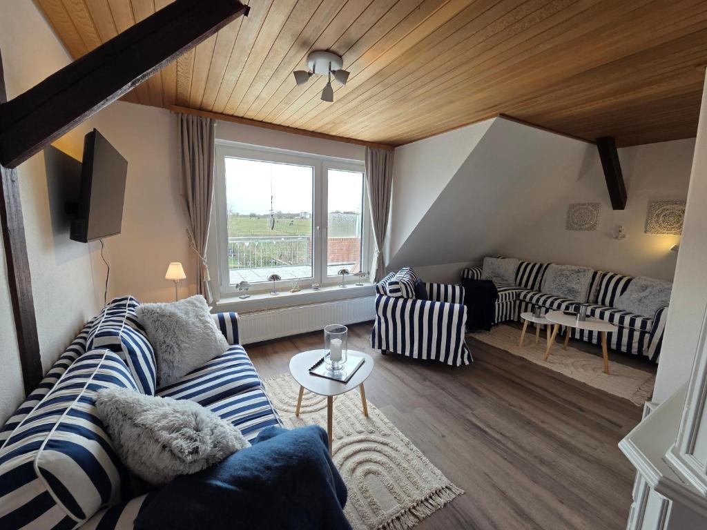 a living room with a couch and a table at Haus Dorfschmiede, Wohnung Anker in Alkersum