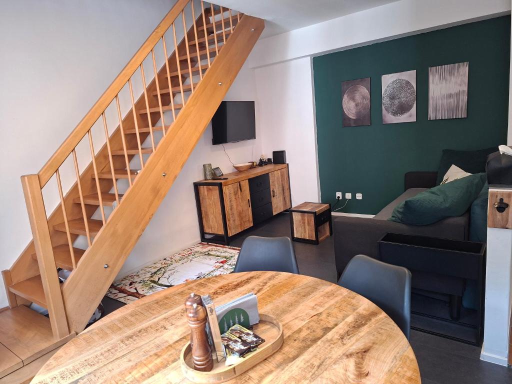a living room with a table and a staircase at Apartmán 19 MEZONET in Jáchymov