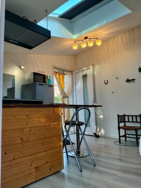 a kitchen with a table and chairs in a room at studio dans les arbres in Saint-Paulet-de-Caisson