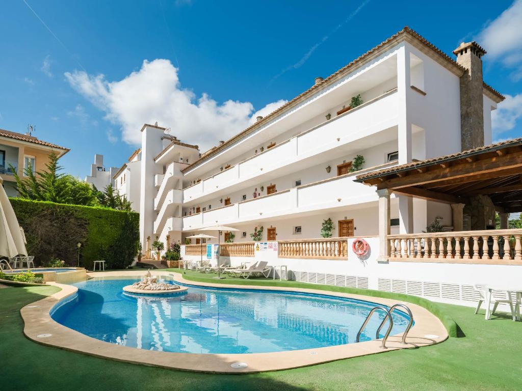 a hotel with a swimming pool in front of a building at Apartaments Sa Torre by SUREDA MAS in Canyamel