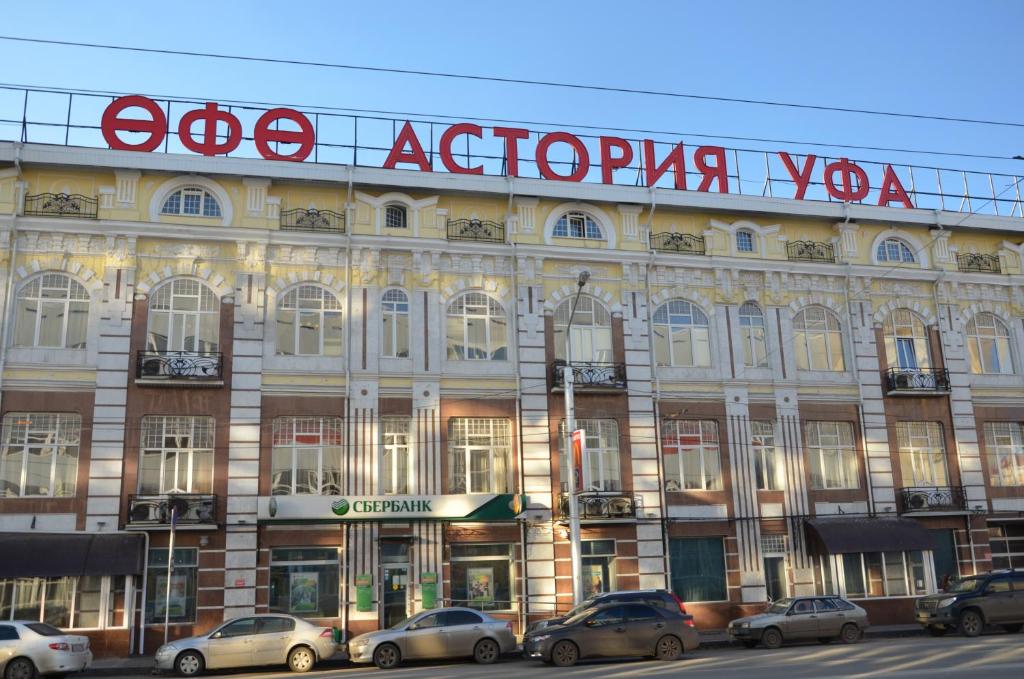 un gran edificio con coches estacionados frente a él en Гостиница Уфа-Астория, en Ufa