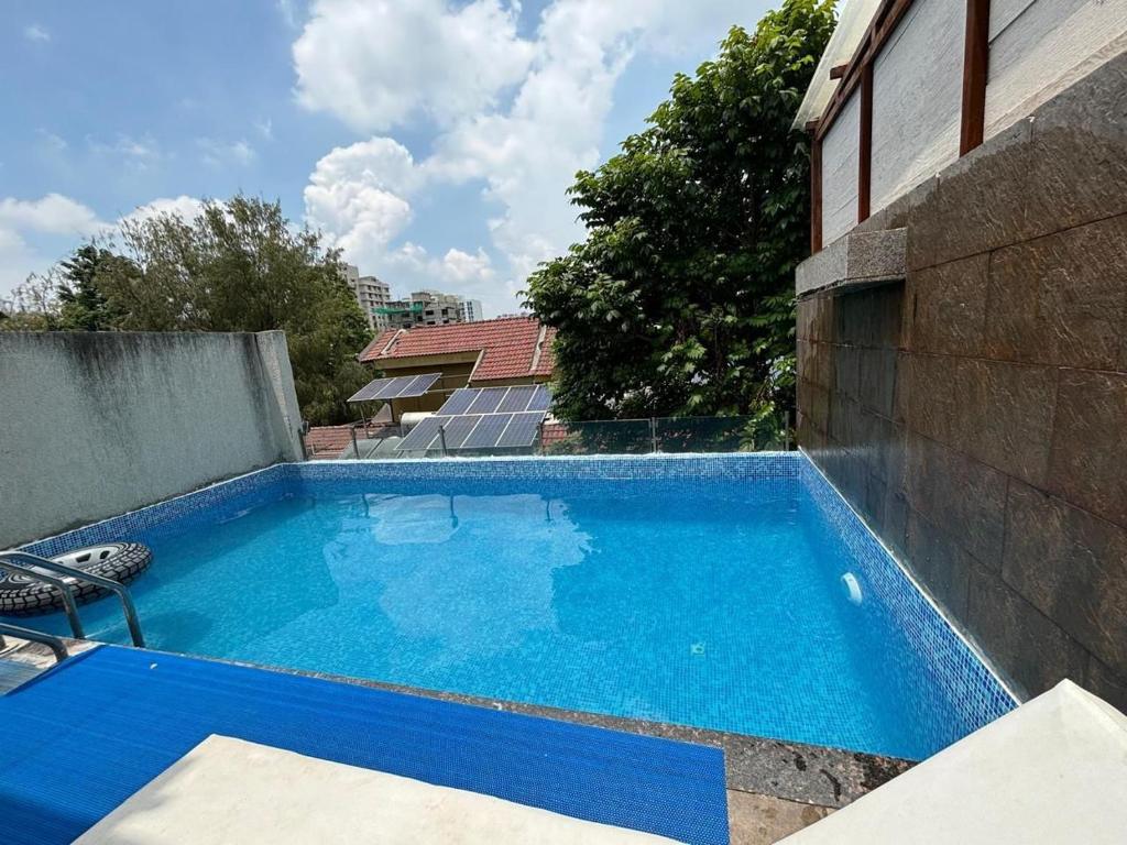 a large blue swimming pool next to a building at Sunleaf Palace in Pune