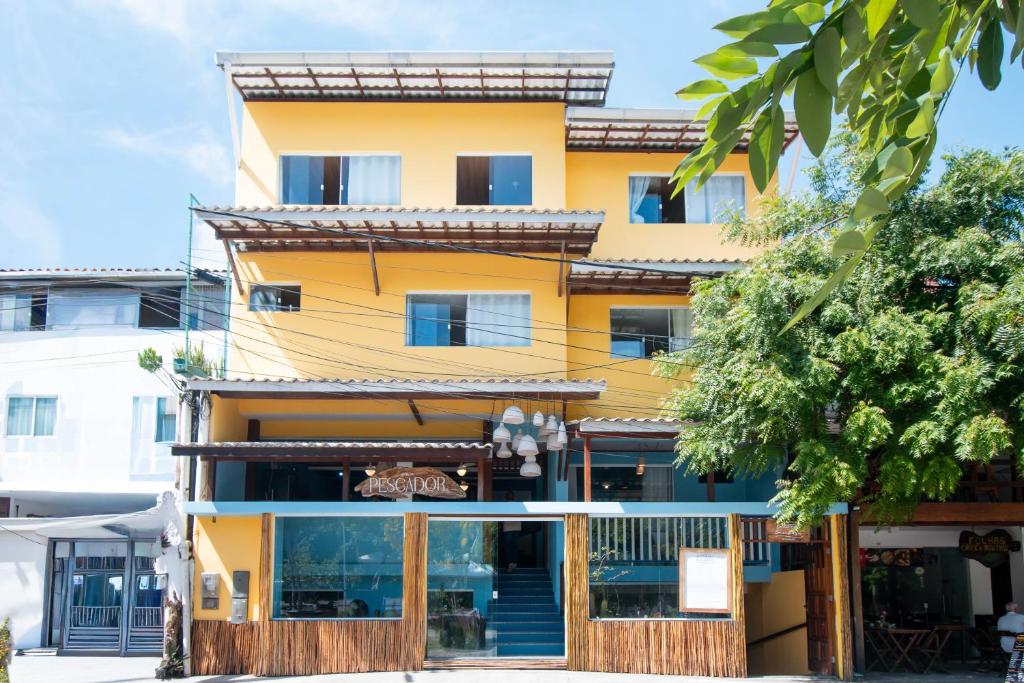a yellow building with a restaurant in front of it at Hotel do Pescador in Morro de São Paulo