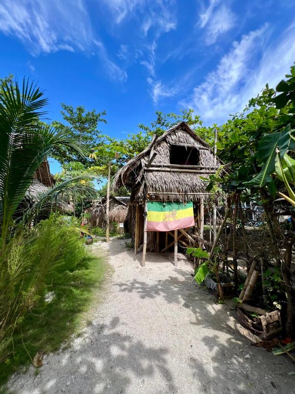 a small hut with a thatched roof on a beach at Tribal Huts Community in Malapascua Island