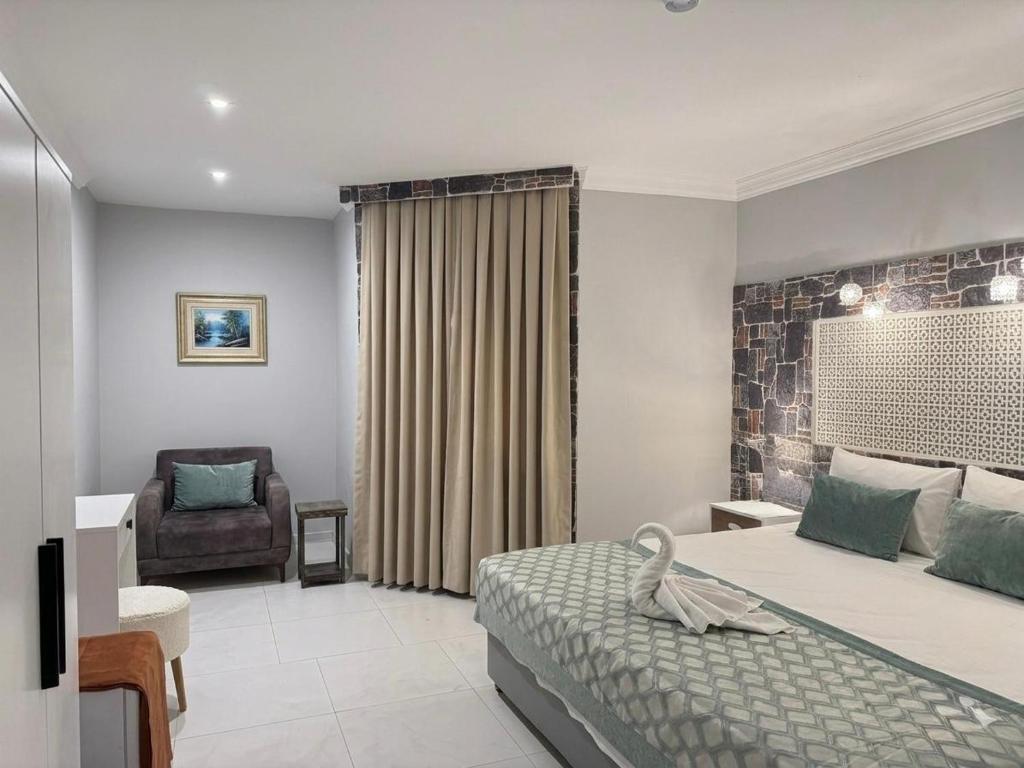 a hotel room with a bed and a chair at Salinas Hotel in Gümbet