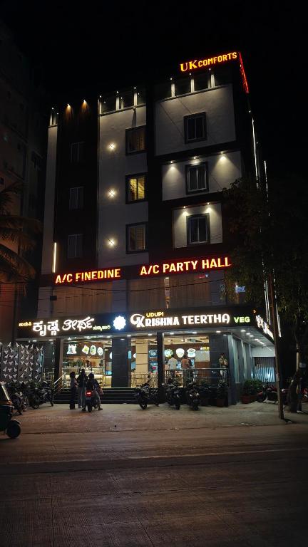 a large apartment building at night with motorcycles parked outside at UK Comforts in Bangalore