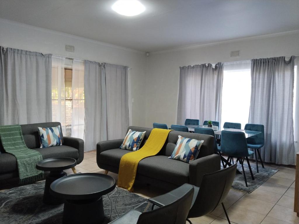 a living room with a couch and chairs at Five-Bedroom House at 27 Baobab Avenue, Birchleigh, Kempton Park, Backup Power Supply in Kempton Park