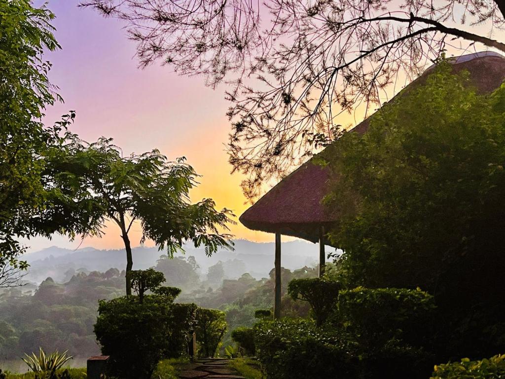a house with a view of a valley at sunset at Mwamba Kelele Lodge in Kasenda