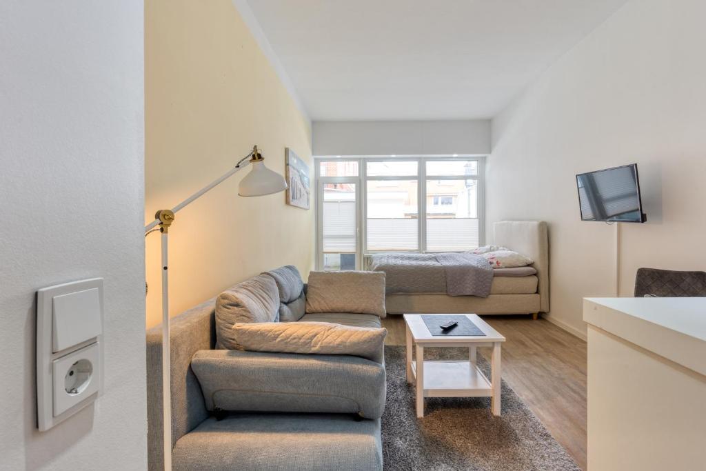 a living room with a couch and a tv at Alte Teestube 55 in Norderney
