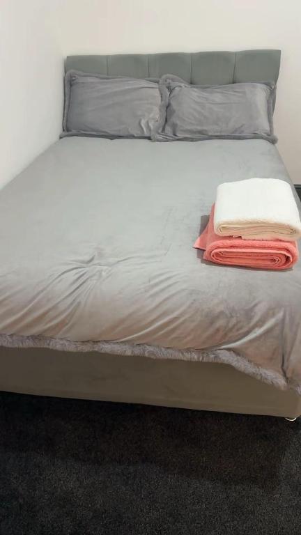 a bed with two towels on top of it at PLUS Properties Westport 3 in Stoke on Trent