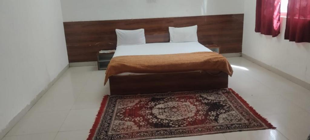 a bedroom with a bed and a rug on the floor at Hotel & Bothgaya Waterpark in Bodh Gaya