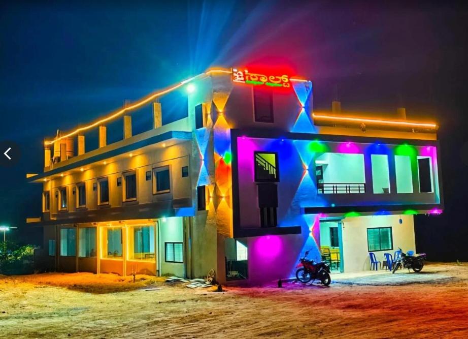 a building with colorful lights on it at night at Salt Restaurant and Lodging in Navalgund