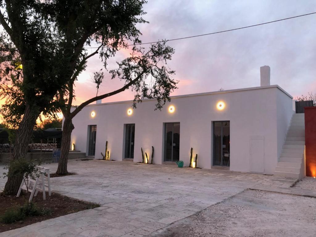 a white building with a tree in front of it at Masseria Noja in Noci