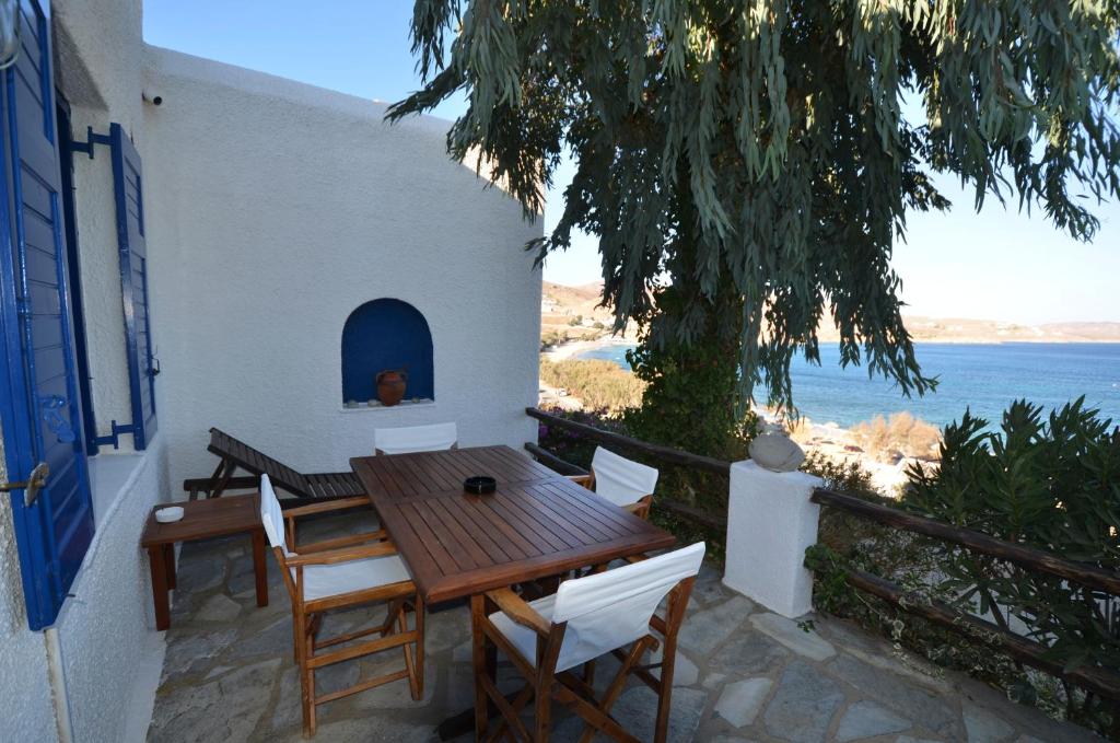 einen Tisch und Stühle auf einer Terrasse mit Meerblick in der Unterkunft Villas Kalafatis Apartments in Kalafatis