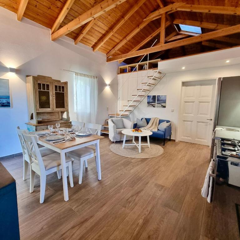 a kitchen and living room with a table and chairs at The House of Waves in Kotrónion