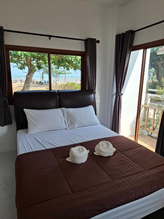 a bedroom with a bed with two hats on it at Lamae Beachfront Villa in Ban Laem No