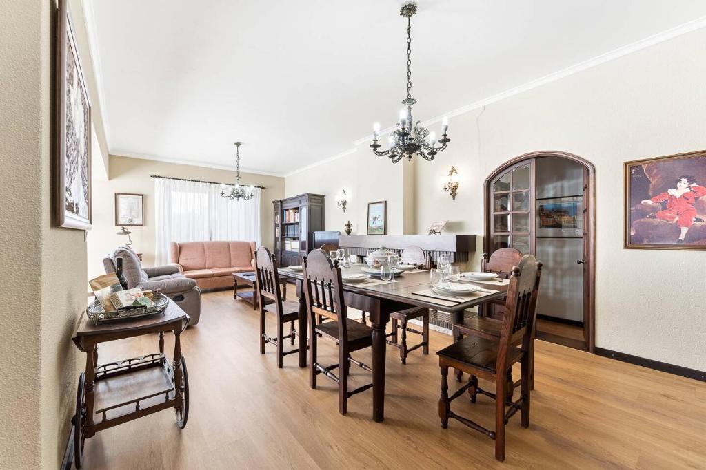 a dining room and living room with a table and chairs at Casa da Betinha in Ílhavo