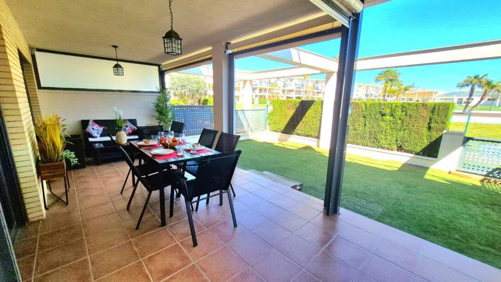 a dining room with a table and chairs on a patio at Panoràmic Vinaros in Sant Jordi