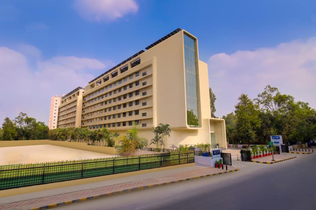 a large building with a tennis court in front of it at Keys Prima by Lemon Tree Hotels, Whitefield, Bengaluru in Bangalore