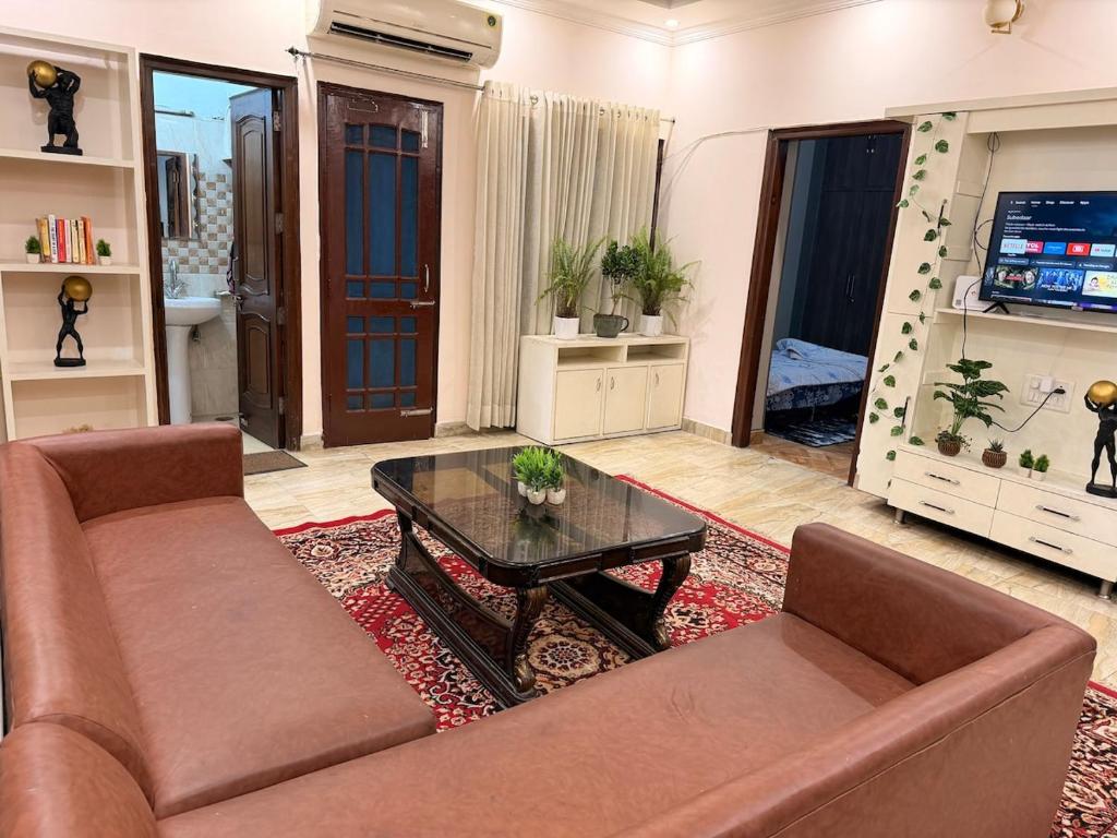 a living room with a couch and a coffee table at Your Cozy Escape in Jammu