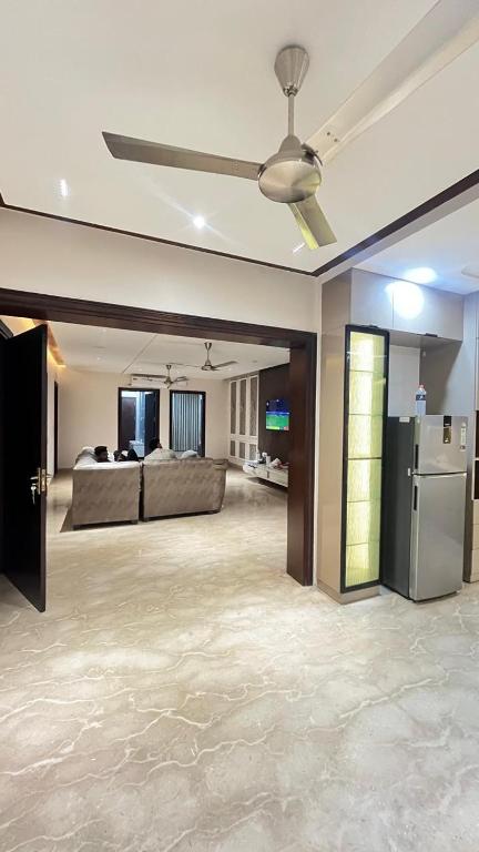 a living room with a ceiling fan and a refrigerator at Thecomfortden in Sohāna